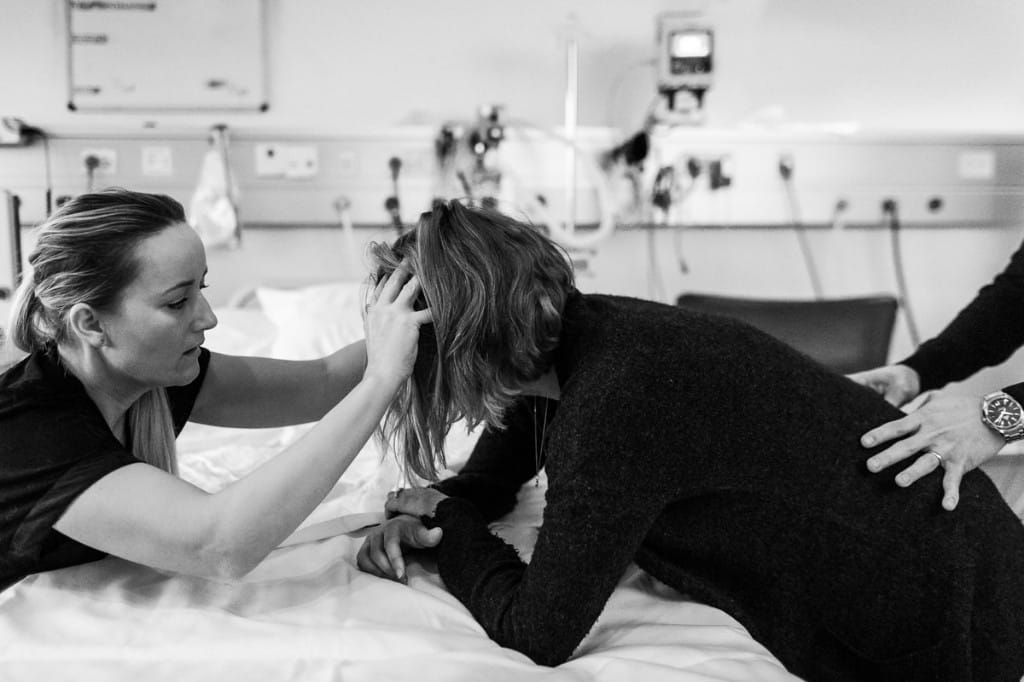 Heidi Meyer holder rummet trygt ved siden af en fødende kvinde, mens partneren støtter fra siden